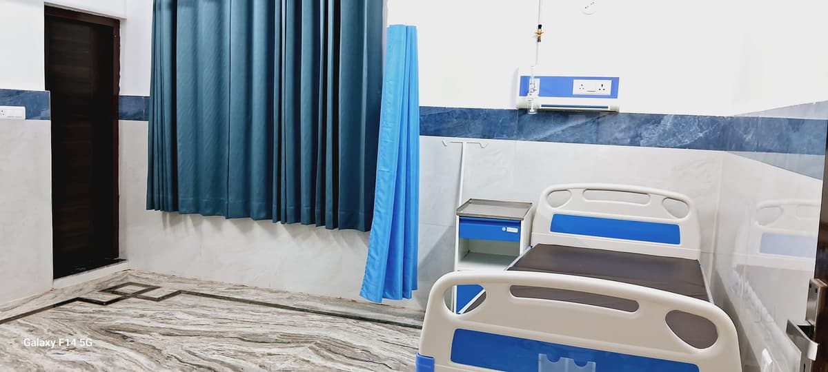 Clean patient ward with hospital bed and blue privacy curtains